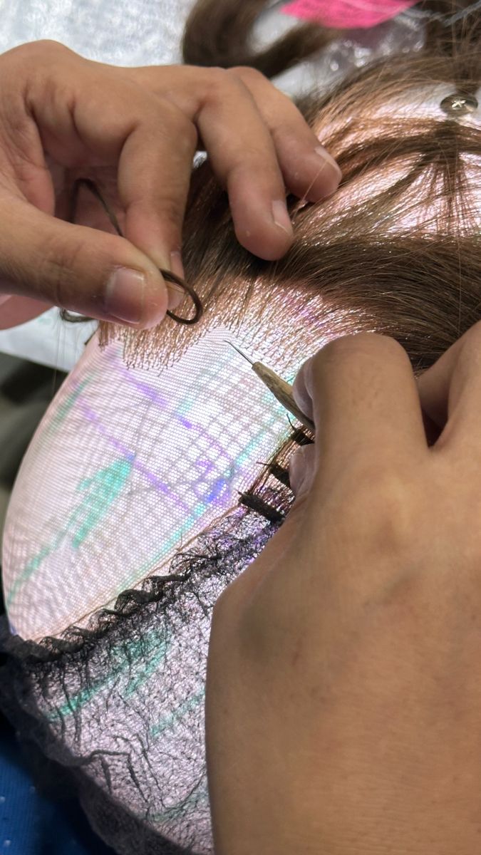 Hand-knotting hair into the lace base